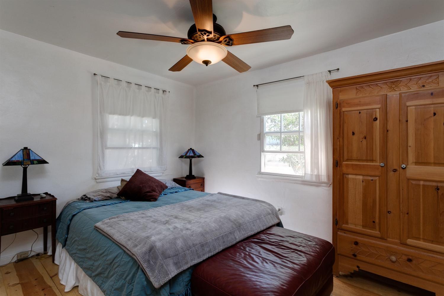195 Grapevine Road Oak View, CA 93022 - Photo 15 of 41 a bedroom with a bed and a chandelier