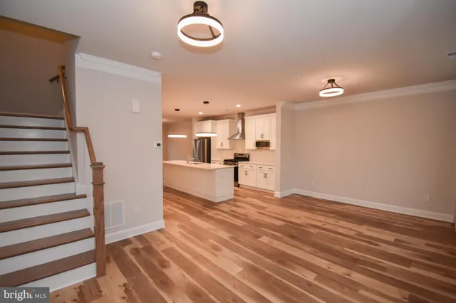 a view of a kitchen with wooden floor and electronic appliances