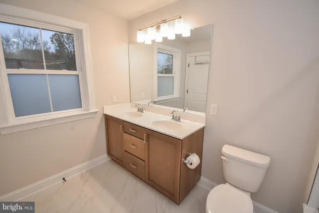 a bathroom with a toilet sink and mirror