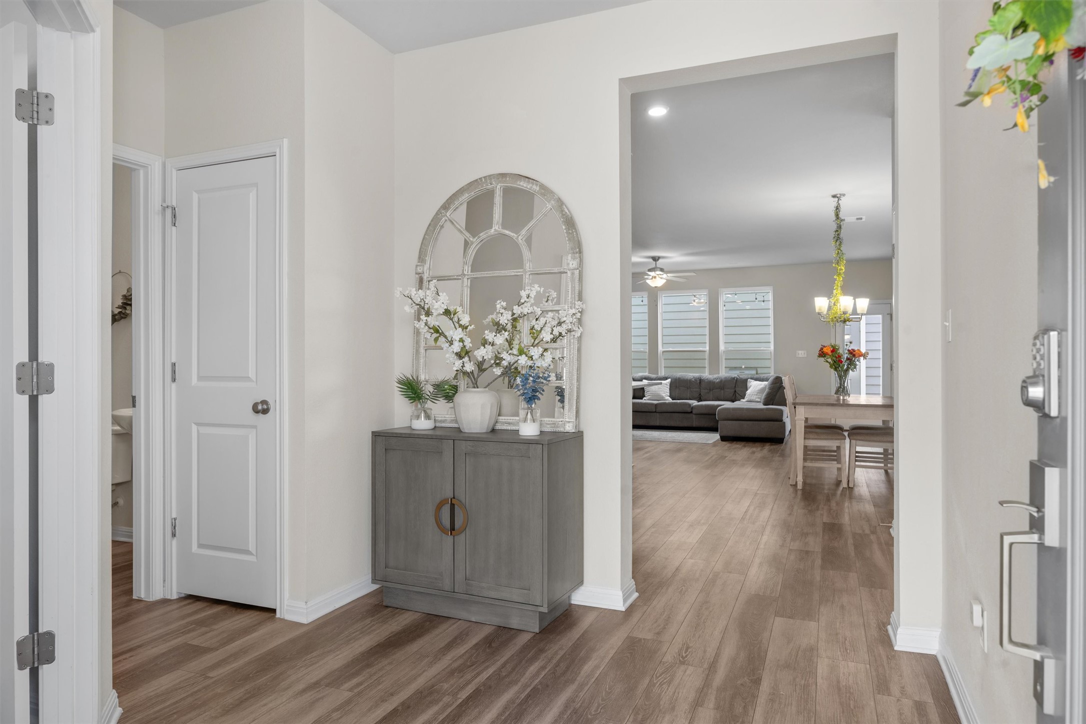 313 Toddy Way Leander, TX 78641 - Photo 4 of 39 Hallway featuring light wood finished floors and a chandelier
