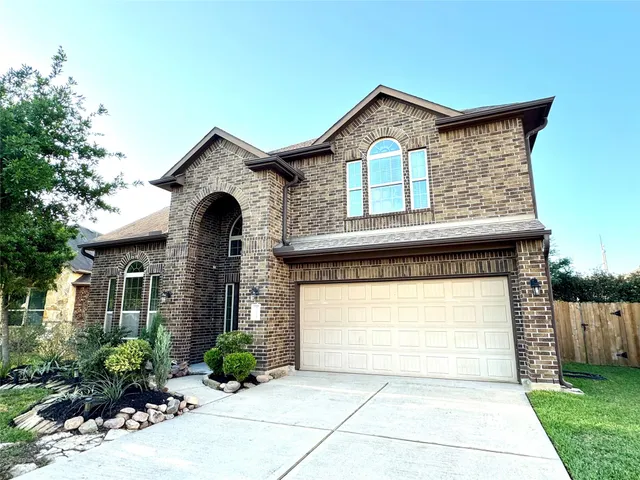 a front view of a house with a yard and green space
