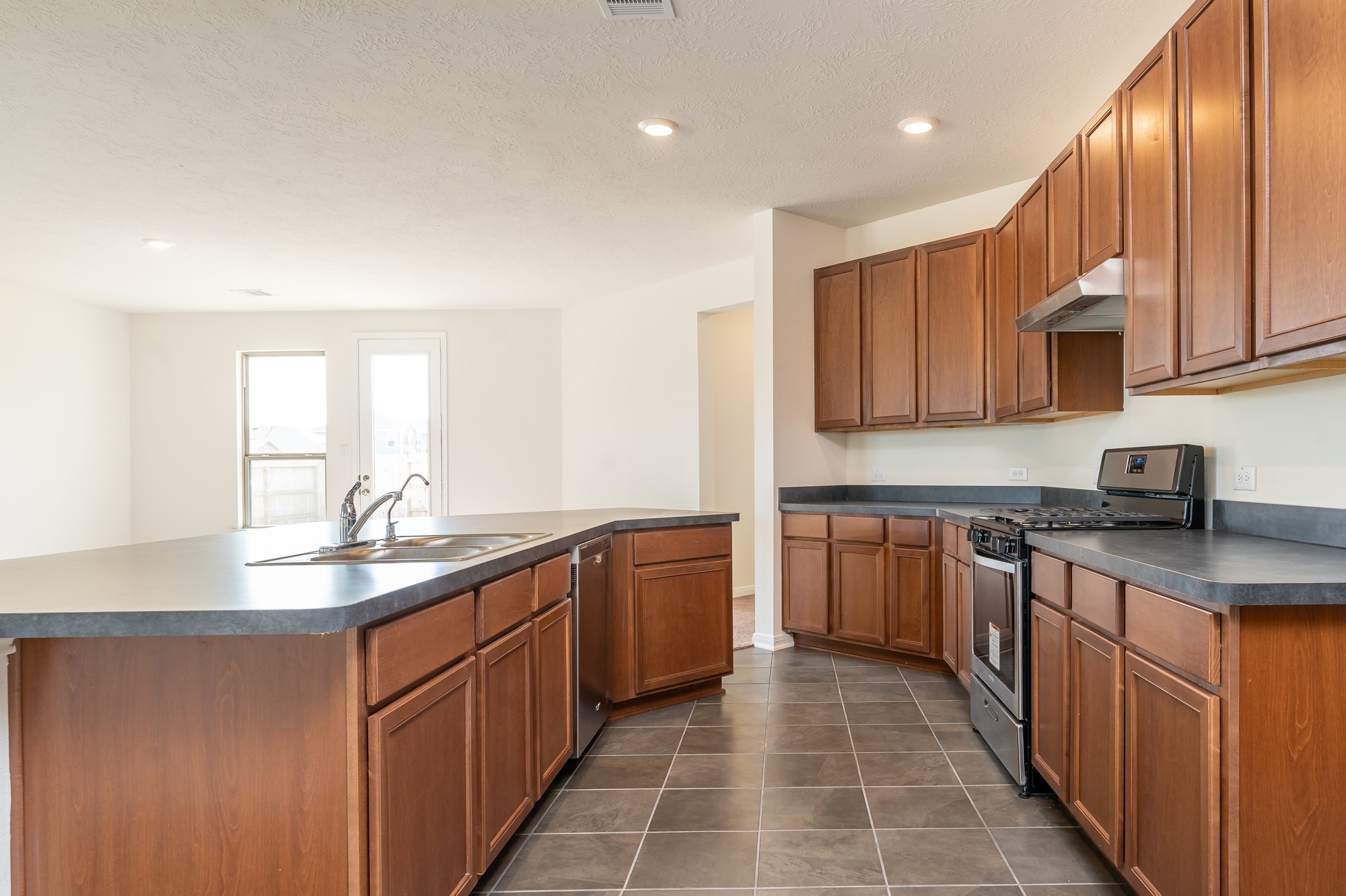 6120 Whitewing Road Rosenberg, TX 77469 - Photo 16 of 35 a kitchen with stainless steel appliances granite countertop a sink stove and cabinets