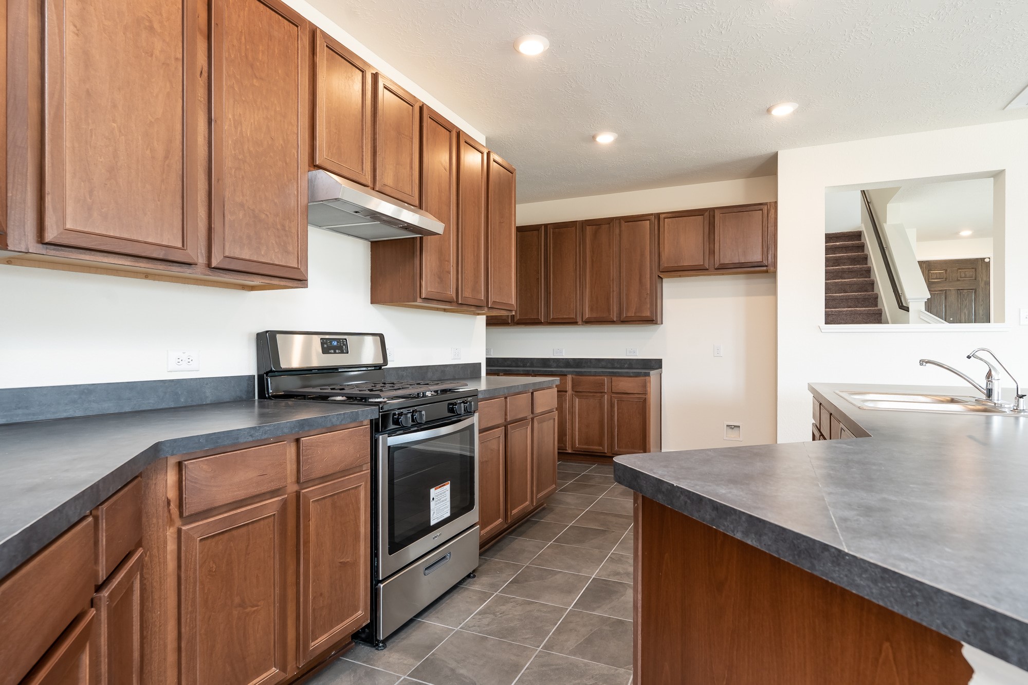 6120 Whitewing Road Rosenberg, TX 77469 - Photo 17 of 35 a kitchen with stainless steel appliances granite countertop a sink a stove and a microwave