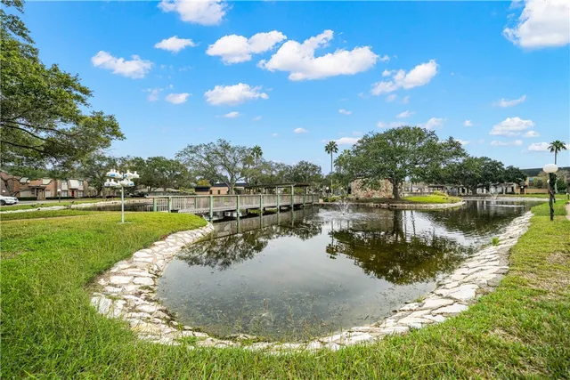a view of a lake with a yard and trees