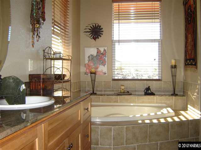 100 Antelope Valley Road Reno, NV 89506 - Photo 8 of 9 a bathroom with a granite countertop sink and a large mirror next to a window