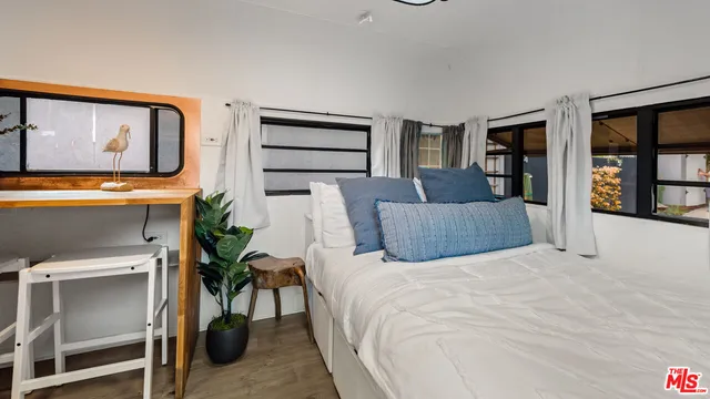 a bedroom with a large bed and potted plant on th wall