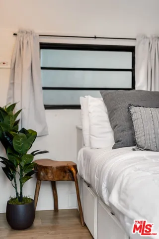 a bedroom with a bed and a potted plant