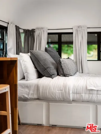 a bedroom with a bed and a large window