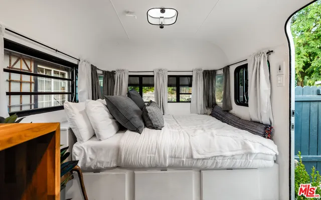 a bedroom with bed and glass window