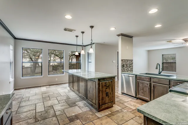 a large kitchen with stainless steel appliances granite countertop a stove and a sink