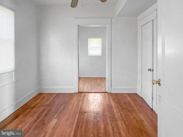 an empty room with wooden floor and a window