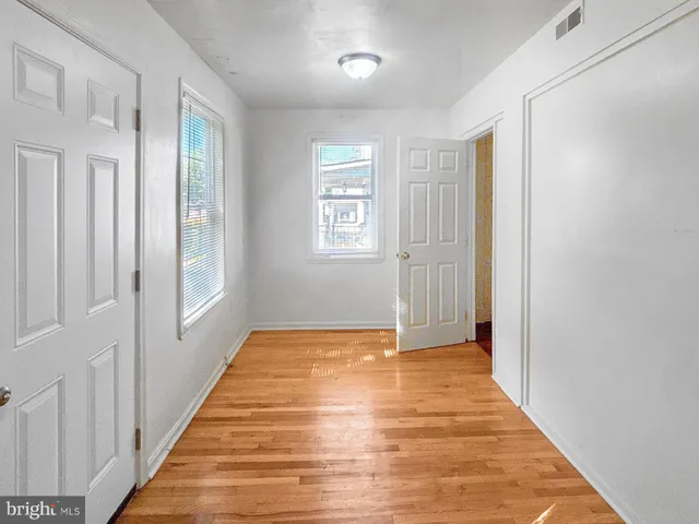 a view of an empty room with wooden floor