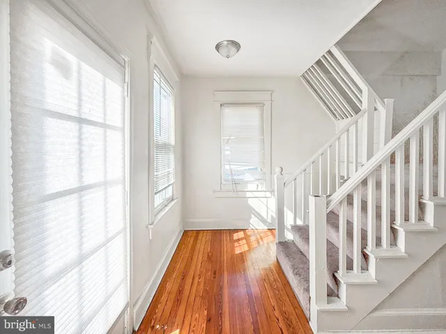 a view of a hallway with wooden floor and staircase