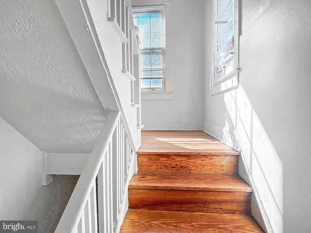 a view of staircase with white walls and a window