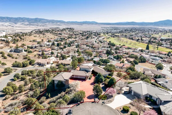 an aerial view of house with yard and mountain view in back
