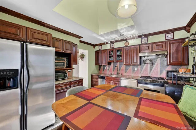 a kitchen with stainless steel appliances granite countertop a refrigerator and a stove top oven
