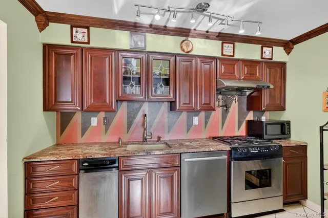 a kitchen with stainless steel appliances granite countertop a stove and cabinets