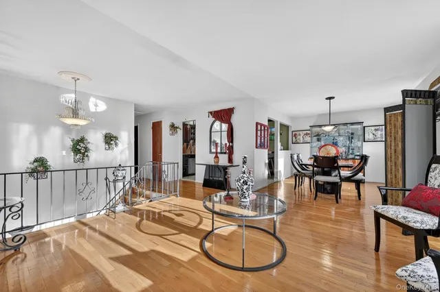 a living room with furniture a chandelier and a dining table