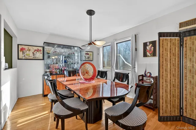 a view of a dining room and livingroom with furniture wooden floor a chandelier