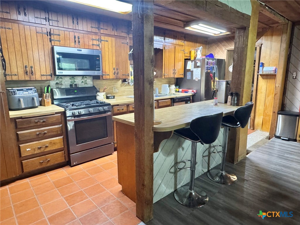 3221 West Ave R Temple, TX 76504 - Photo 15 of 48 a kitchen with stainless steel appliances granite countertop a stove a sink and a refrigerator