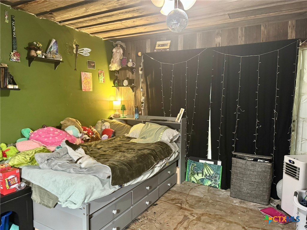 3221 West Ave R Temple, TX 76504 - Photo 32 of 48 a bedroom with a bed and a chandelier