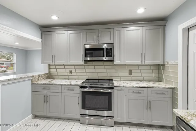 a kitchen with white cabinets and appliances