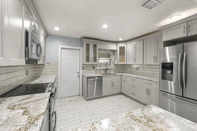 a kitchen with a refrigerator sink and cabinets
