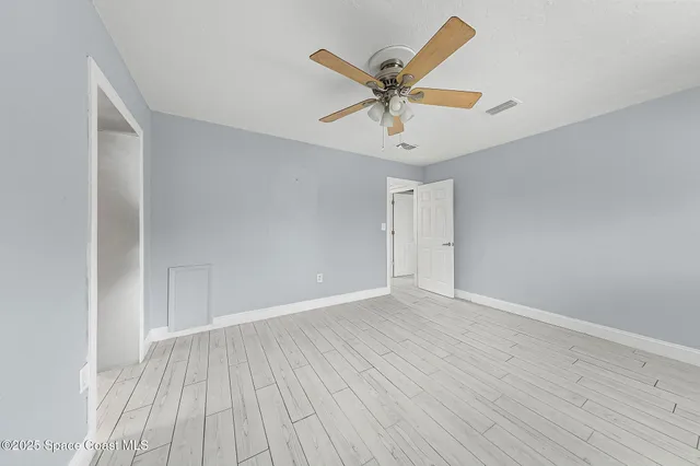 a view of a big room with wooden floor closet and windows