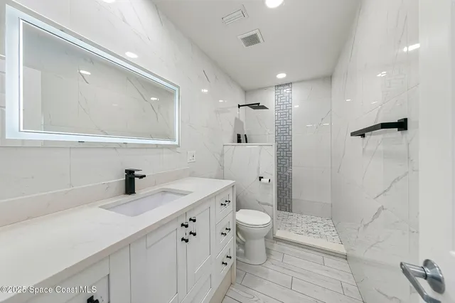 a bathroom with a double vanity sink a toilet and a shower
