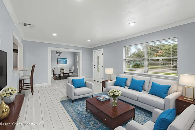 a living room with furniture wooden floor and a large window