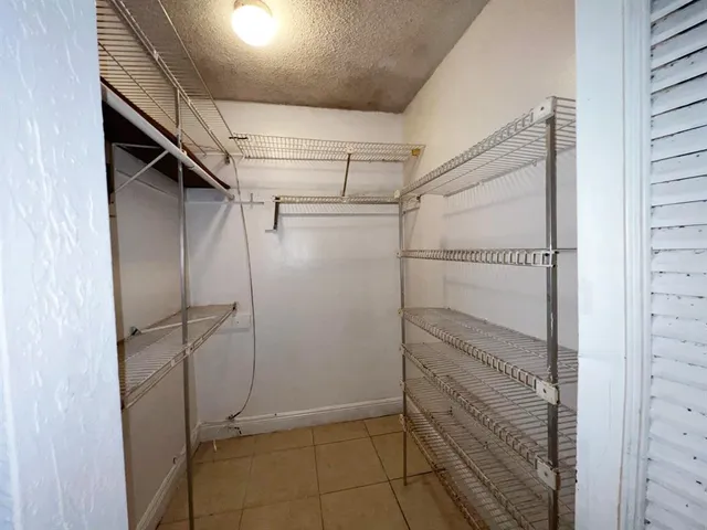 an empty room & kitchen space with mirror