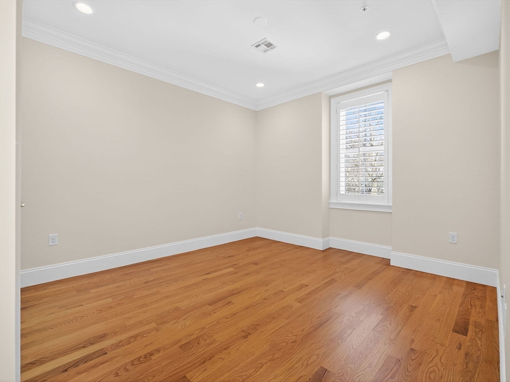 213 Lamartine Street, Unit 213A Boston, MA 02130 - Photo 25 of 39 an empty room with wooden floor and windows