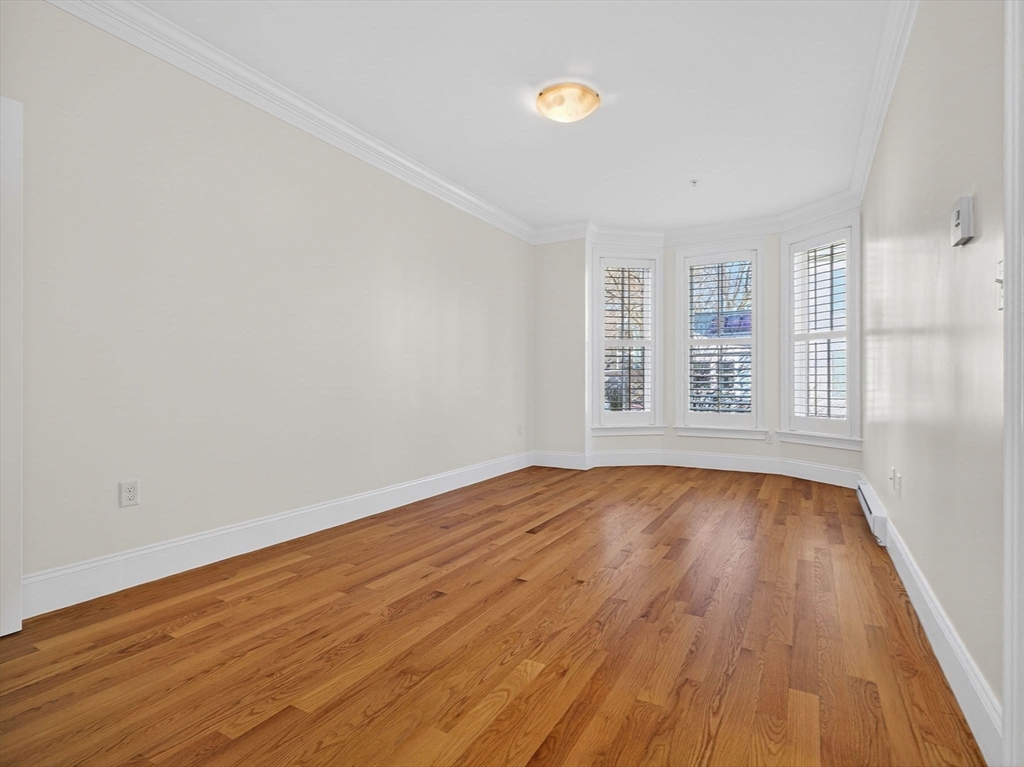 213 Lamartine Street, Unit 213A Boston, MA 02130 - Photo 28 of 39 wooden floor in an empty room with a window
