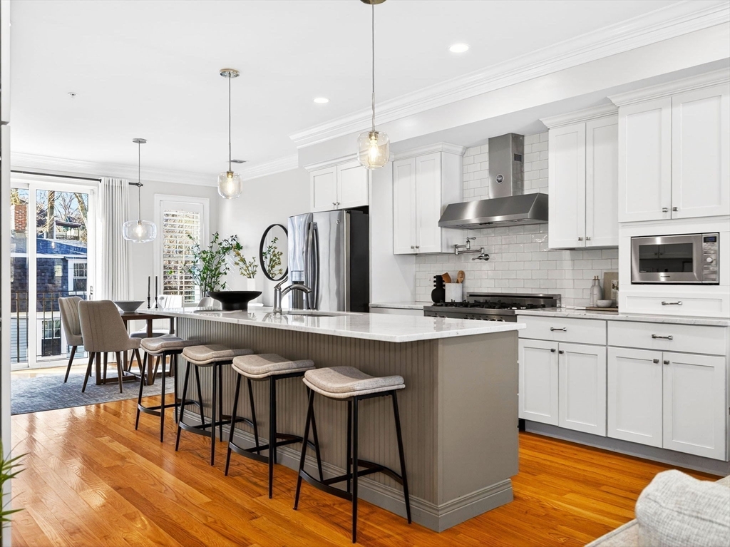 213 Lamartine Street, Unit 213A Boston, MA 02130 - Photo 4 of 39 a kitchen with stainless steel appliances granite countertop a stove top oven a sink a island a dining table and chairs
