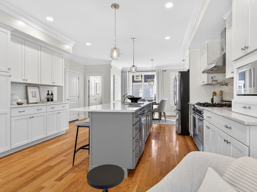 213 Lamartine Street, Unit 213A Boston, MA 02130 - Photo 6 of 39 a kitchen with stainless steel appliances granite countertop a refrigerator a sink dishwasher a stove and white cabinets with wooden floor