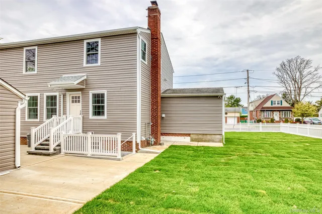 a view of a house with a yard and pathway