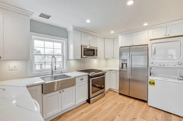 a kitchen with stainless steel appliances granite countertop a refrigerator a stove a sink and a microwave