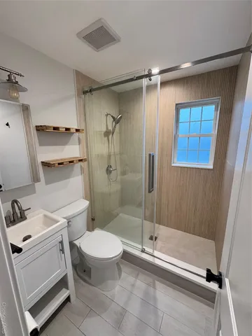 a bathroom with a toilet a sink and shower