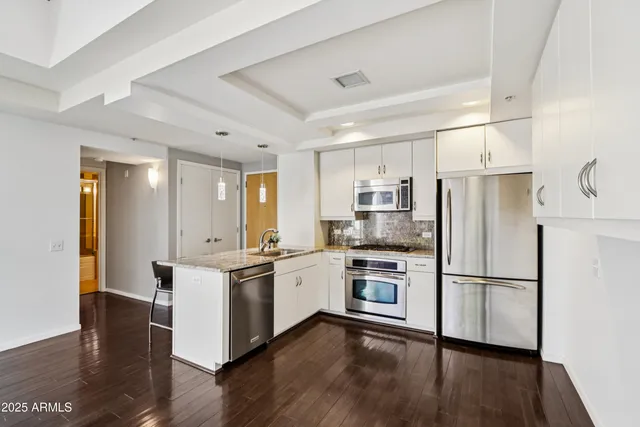 a kitchen with stainless steel appliances a refrigerator a stove top oven and a refrigerator