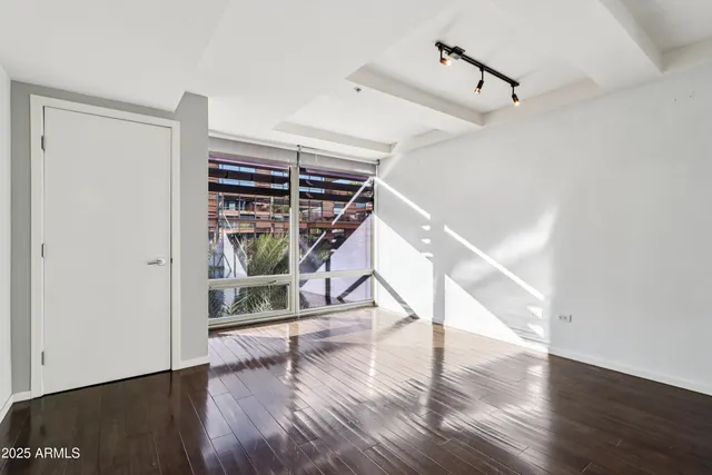 a view of empty room with wooden floor and fan