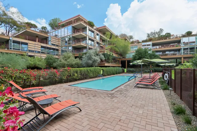 a front view of a multi story residential apartment building with yard and sign board