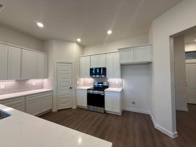 a kitchen with cabinets and stainless steel appliances