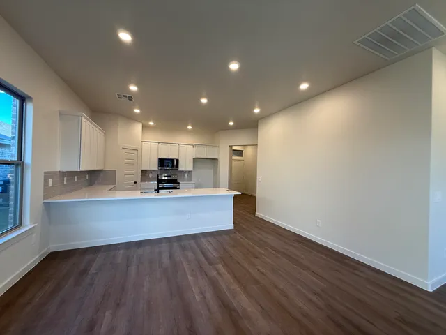 a large kitchen with cabinets table and chairs