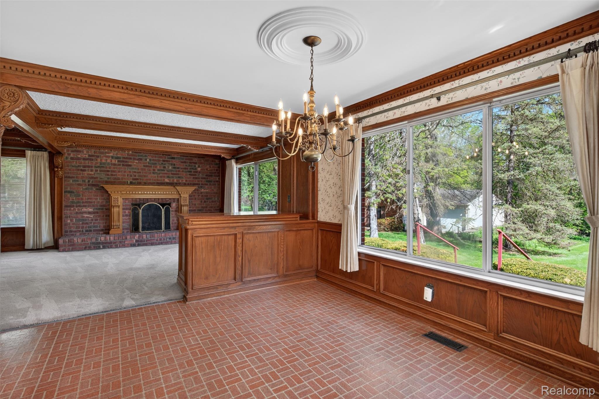 15623 Millar Road Clinton Township, MI 48036 - Photo 46 of 56 Unfurnished dining area with brick patterned floors, a chandelier, a wainscoted wall, a brick fireplace, and wood walls
