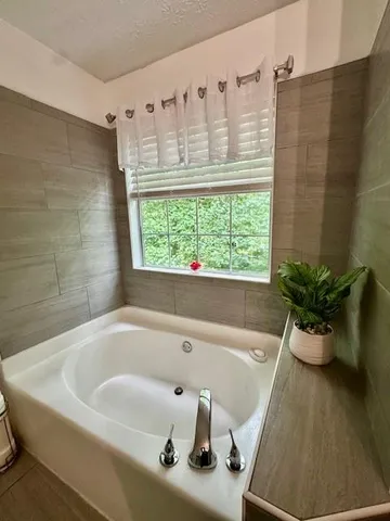 a bath tub sitting in a bathroom next to a window