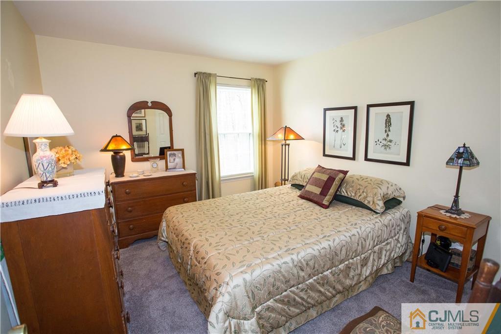1301 Timber Oaks Road, Unit 1301 Edison, NJ 08820 - Photo 23 of 25 a bedroom with a bed and a potted plant on the dresser