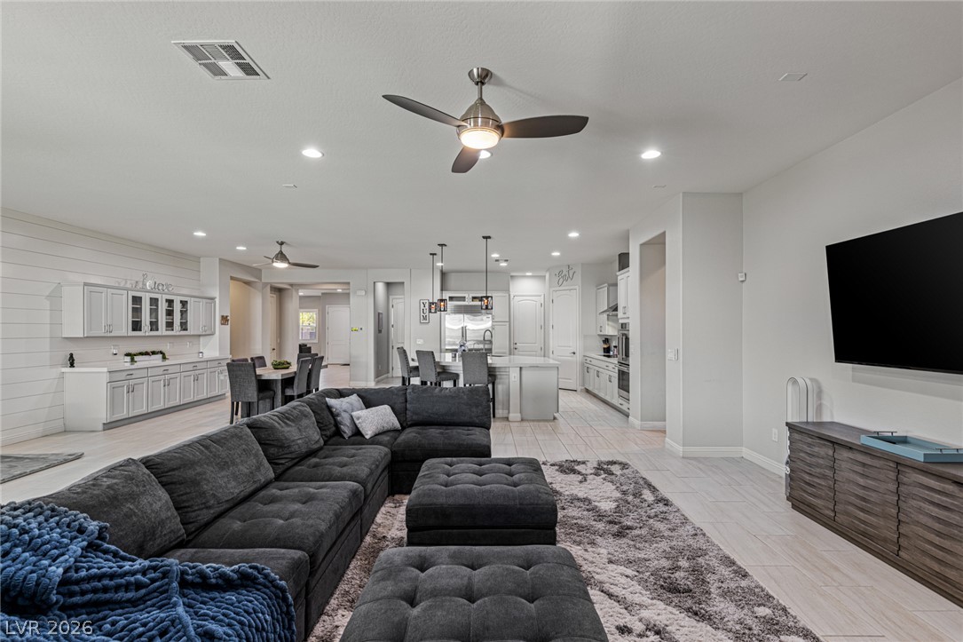 7036 Arabian Ridge Street Las Vegas, NV 89131 - Photo 20 of 64 An open concept living area seamlessly connects to a modern kitchen and dining space, ideal for entertaining.