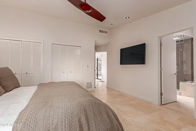 a spacious bedroom with a bed and cabinet