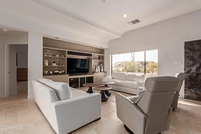 a living room with furniture a fireplace and a floor to ceiling window