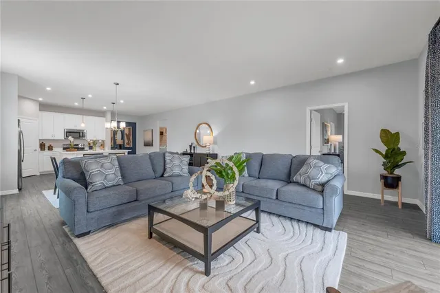a living room with furniture and view of kitchen